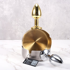 Gold and silver anal plug with a polished finish, featuring a rounded base and an ashtray-style top.