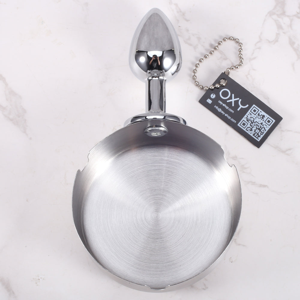 Anal plug with a shiny chrome finish and integrated ashtray-style top, designed for BDSM roleplay and humiliation scenes.